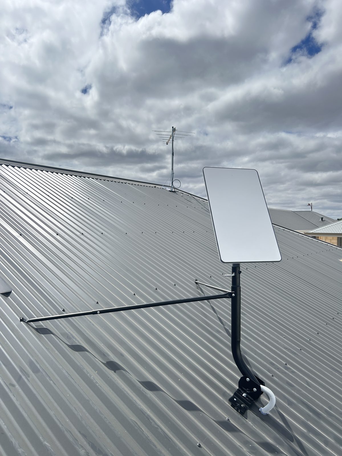 Starlink dish and TV antenna installed together on tin roof