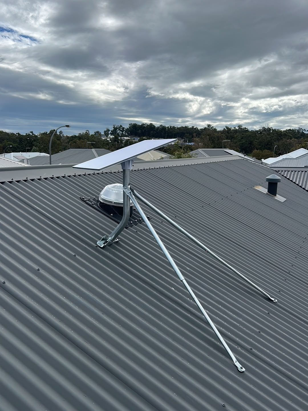 Starlink dish and TV antenna on tin roof — side view